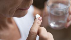 Una mujer tomándose una pastilla
FIZKES