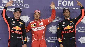 Ferrari&#039;s German driver Sebastian Vettel (C) waves after securing pole position beside Red Bull&#039;s Dutch driver Max Verstappen (L) and Red Bull&#039;s Australian driver Daniel Ricciardo after the qualifying session of the Formula One Singapore Grand Prix in Singapore on September 16, 2017.  / AFP PHOTO / Mohd RASFAN