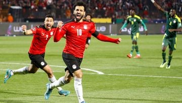 Egypt's forward Mohamed Salah (R) and Egypt's midfielder Mahmoud 'Trezeguet' Hassan (L) celebrate after a goal during the 2022 Qatar World Cup African Qualifiers football match between Egypt and Senegal at Cairo International Stadium in the Egyptian capital on March 25, 2022. (Photo by Khaled DESOUKI / AFP)