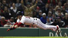 Boston Red Sox&#039;s Andrew Benintendi dives for home plate as he beats the throw to score on a sacrifice fly by Xander Bogaerts during the eighth inning of a baseball game against the Oakland Athletics at Fenway Park, Monday, April 29, 2019, in Boston. 