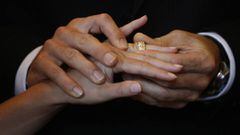 Un hombre pone un anillo de boda a su futura esposa.