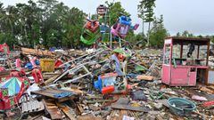 A woman salvages valuables items from a temporary amusement park that was hit by a tsunami at the Sumber Jaya village in Sumur, Pandeglang, Banten province on December 25, 2018, three days after the tsunami - caused by activity at a volcano known as the &