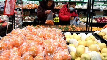 People shop for fruit at a market in Beijing on February 16, 2022.