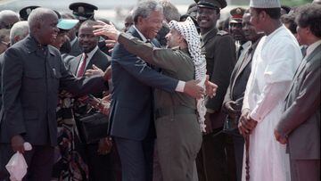 FILE PHOTO: Nelson Mandela (L) is embraced by PLO leader Yasser Arafat as he arrives at Lusaka airport February 27, 1990.  REUTERS/Howard Burditt/File Photo