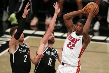 Oct 27, 2021; Brooklyn, New York, USA; Miami Heat forward Jimmy Butler (22) controls the ball against Brooklyn Nets forward Blake Griffin (2) and forward Joe Harris (12) during the third quarter at Barclays Center. Mandatory Credit: Brad Penner-USA TODAY 