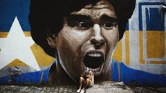 Una seguidora de Diego Armando Maradona llora su muerte delante de un graffiti suyo. 