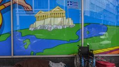 A homeless man sleeps outside a closed shop in Athens on April 6, 2020. - The pandemic precipitated municipal and solidarity actions to respond to chronic shortages of social assistance. Athens municipality opened a home for the hundreds of homeless to pr