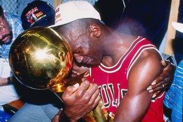 Michael Jordan abraza el trofeo que le acreditaba como campeón de las Finales de 1991 frente a los Lakers. En la instantánea se puede ver al escolta emocionado agarrado el trofeo y abrazado por su padre y su esposa. Estas finales de la NBA serían las prim