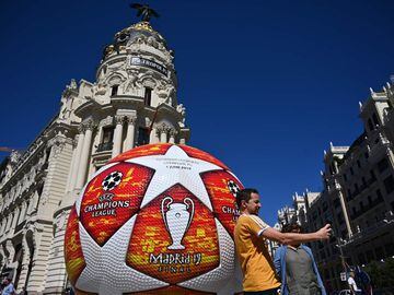 A passerby takes a selfie with a giant replica of the UEFA Champions League ball displayed in Madrid on May 29, 2019 ahead of the final football match between Liverpool and Tottenham Hotspur on June 1. 