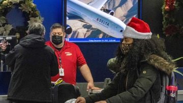 Travelers move through Delta Airlines check-in at Los Angeles International Airport  in Los Angeles, California, on December 23, 2021. - Over 2,000 flights have been cancelled and thousands delayed around the world as the highly infectious Omicron variant