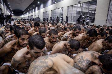 Pasillos del Centro de Confinamiento del Terrorismo, lleno de pandilleros esposados en el suelo mientras esperan a ser llevados a su celda.