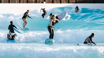 Varios surfistas surfeando en la zona de principiantes de la ola artificial para el surf Wavegarden Cove.