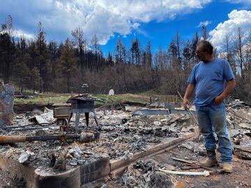 Daniel Encinias stands next to the ruins of his home destroyed by the Hermits Peak Calf Canyon fire in Tierra Monte, New Mexico.