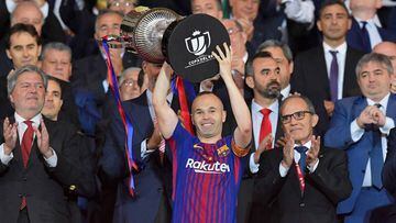 Barcelona&#039;s Spanish midfielder Andres Iniesta (C) holds the trophy after the Spanish Copa del Rey (King&#039;s Cup) final football match Sevilla FC against FC Barcelona at the Wanda Metropolitano stadium in Madrid on April 21, 2018.  Barcelona won 5