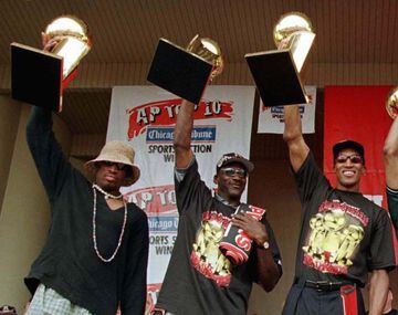 Bulls Dennis Rodman (L) Michael Jordan (C) and Scottie Pippen hold up their NBA Championship trophies at a victory rally in this June 16, 1997 file photo. The Bulls, winners of the last three NBA titles, will be without their big three players this year a