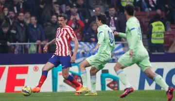 El jugador del Atlético de Madrid, Savic, controla el balón delante del jugador del Getafe, Ünal. 
 