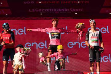 Thomas y Almeida acompañan a Roglic, que hace la pose del 'telemark' junto a su hijo, en el podio final del Giro.