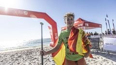 Lucas Simoncelli posa con la bandera de Espa&ntilde;a y una sonrisa en una playa de Dinamarca tras lograr el oro en el Europeo de Stand Up Paddle Surf. 