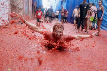 A reveller slides in tomato pulp during the annual Tomatina festival in Bunol near Valencia, Spain, August 30, 2017. REUTERS/Heino Kalis
