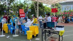 People queue to undergo nucleic acid testing for the Covid-19 coronavirus in the city of Ruili which borders Myanmar, in China&#039;s southwestern Yunnan province on July 8, 2021. (Photo by STR / AFP) / China OUT