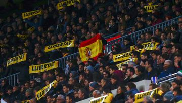Un aficionado muestra una bandera de Espa&ntilde;a entre los mensajes a favor de la libertad de los presos pol&iacute;ticos durante el partido de vuelta de los Octavos de final de la Copa del Rey que disputan esta noche el FC Barcelona y el Celta de Vigo 