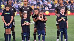 A child blocks her ears to avoid the sound from fire crackers while standing with Jamaica's players for the national anthems during the 2023 Cup of Nations women�s football match between Australia and Jamaica in Newcastle on February 22, 2023. (Photo by SAEED KHAN / AFP) / -- IMAGE RESTRICTED TO EDITORIAL USE - STRICTLY NO COMMERCIAL USE --