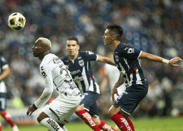Matias Kranevitter (R) of Monterrey and with Julian Quinones (L) of Atlas eye the ball during the Mexican Apertura tournament football match at BBVA Bancomer stadium in Monterrey, Mexico, on November 24, 2021. (Photo by Julio Cesar AGUILAR / AFP)