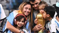 Argentina's defender #08 Marcos Acuna, his wife Julia Silva (L) and their children Mora (L), Martina (2ndR) and Benjamin pose with the FIFA World Cup Trophy after Argentina won the Qatar 2022 World Cup final football match between Argentina and France at Lusail Stadium in Lusail, north of Doha on December 18, 2022. (Photo by Kirill KUDRYAVTSEV / AFP)