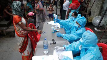 A healthcare worker checks the temperature of a resident during a medical campaign for the coronavirus disease at a slum area in Mumbai. 