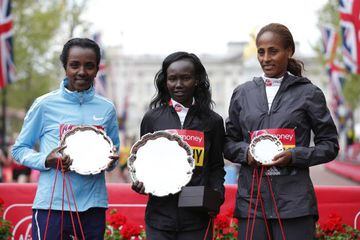 Kenya's Mary Keitany poses with the trophy as she celebrates winning the Women's Elite race with second placed Ethiopia's Tirunesh Dibaba and third placed Aselefech Mergia Medessa.