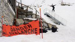 Peter Heads se grinda una barandilla con su tabla de snowboard en alg&uacute;n punto del Pirineo, con un cartel de peligro avalanchas en primer plano. 