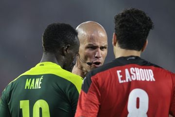 South African referee Victor Gomes (C) speaks to Senegal's forward Sadio Mane (L) and Egypt's midfielder Emam Ashour during the Africa Cup of Nations (CAN) 2021 final football match between Senegal and Egypt at Stade d'Olembe in Yaounde on February 6, 2022. (Photo by Kenzo TRIBOUILLARD / AFP)