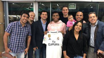 Juni Calafat (third from the left), Real Madrid's head scout and South America specialist, stands to Rodrygo's right as the player holds a club shirt.