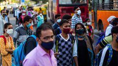 Commuters wearing facemasks as a preventative measure against the Covid-19 coronavirus wait for public bus along a street in New Delhi on October 5, 2020. (Photo by Jewel SAMAD / AFP)