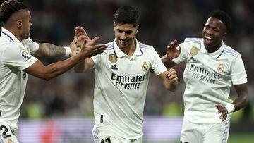 Real Madrid's Spanish midfielder Marco Asensio celebrates with Real Madrid's Brazilian forward Vinicius Junior (R) and Real Madrid's Dominican forward Mariano Diaz (L) scoring his team's first goal during the Spanish league football match between Real Madrid CF and Getafe CF at the Santiago Bernabeu stadium in Madrid on May 13, 2023. (Photo by Thomas COEX / AFP)