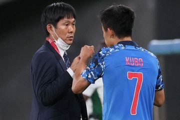 Japan's forward Takefusa Kubo (R) speaks with Japan's coach Hajime Moriyasu after scoring the opening goal during the Tokyo 2020 Olympic Games men's group A first round football match between Japan and South Africa at Tokyo Stadium in Tokyo on July 22, 20
