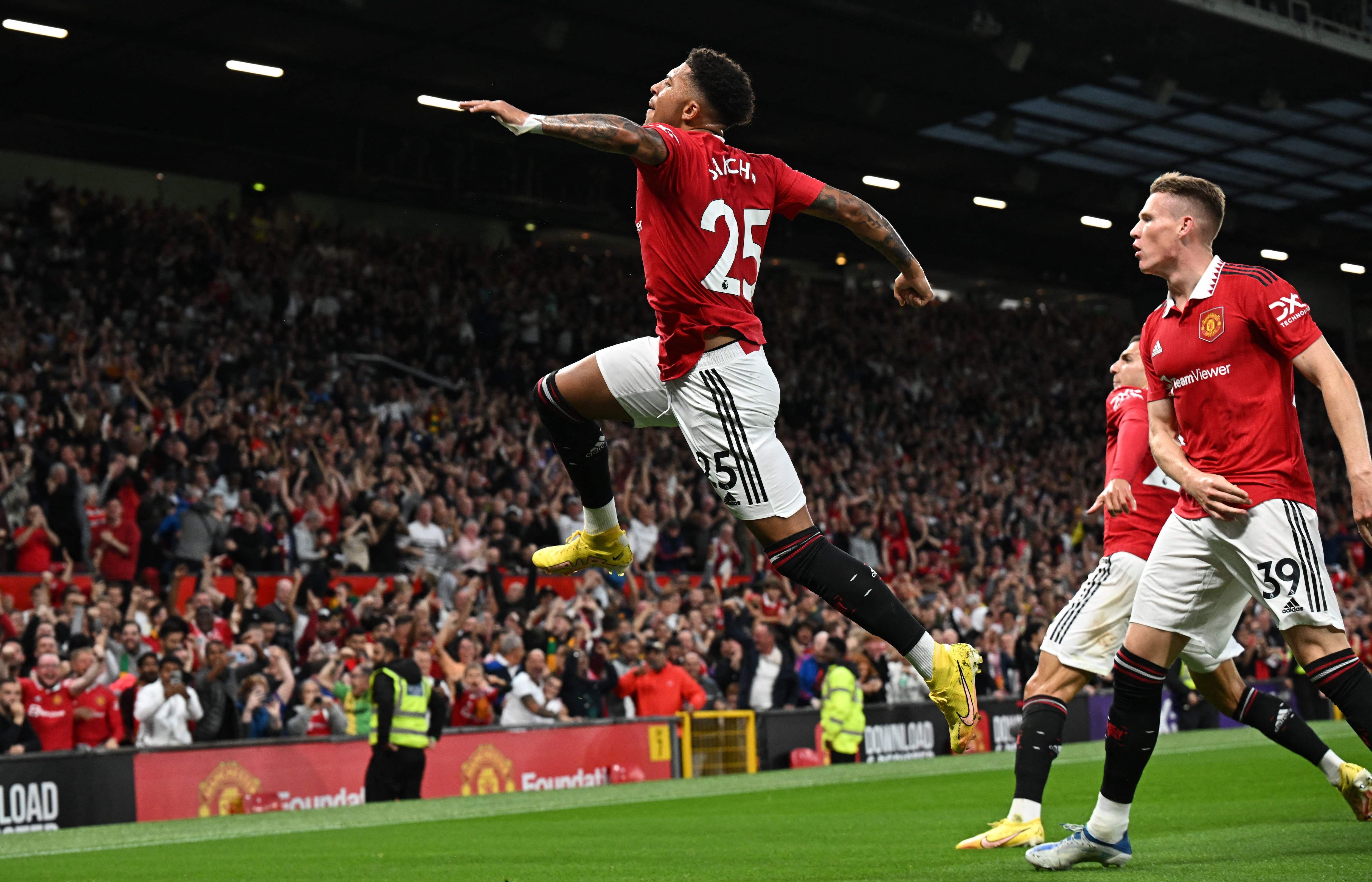 Manchester United's English striker Jadon Sancho (C) celebrates after scoring the opening goal during the English Premier League football match between Manchester United and Liverpool at Old Trafford in Manchester, north west England, on August 22, 2022. (Photo by Paul ELLIS / AFP) / RESTRICTED TO EDITORIAL USE. No use with unauthorized audio, video, data, fixture lists, club/league logos or 'live' services. Online in-match use limited to 120 images. An additional 40 images may be used in extra time. No video emulation. Social media in-match use limited to 120 images. An additional 40 images may be used in extra time. No use in betting publications, games or single club/league/player publications. / 