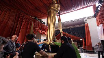 Workers load in a large Oscar statue as preparations continue for the 95th Academy Awards.