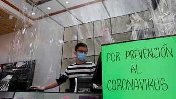 An employe of a store wears a face mask as he works behind a plastic curtain as a precaution against the spread of the coronavirus disease (COVID-19) in Vina del Mar, Chile  March 14, 2020. REUTERS/Rodrigo Garrido
