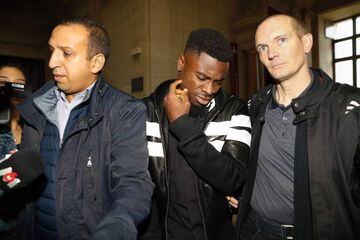 Paris Saint-Germain's defender Serge Aurier (C) arrives to the Paris courthouse early on September 26, 2016 to answer a charge of elbowing a police officer.