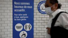 A man wearing a protective face mask walks past a placard with health and social distancing informations at a metro station of Paris transport network (RATP) during the outbreak of the coronavirus disease (COVID-19) in Paris, France, May 5, 2020. REUTERS/