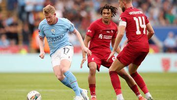 Kevin De Bruyne of Manchester City controls the ball under pressure from Trent Alexander-Arnold (C) and Jordan Henderson of Liverpool (R)