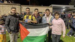 Yaser Hamed posa junto a sus hermanos y la bandera palestina.