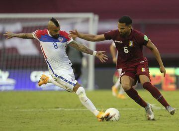 Chile's Arturo Vidal (L) and Venezuela's Yangel Herrera vie for the ball during their closed-door 2022 FIFA World Cup South American qualifier football match at the Olympic Stadium in Caracas on November 17, 2020. (Photo by Edilzon Gamez / various sources