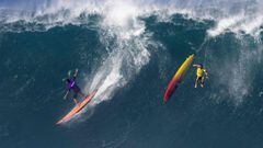 US surfer Eli Olsen rides a wave as Hawaiian surfer Jake Maki gets wiped out during The Eddie Aikau Big Wave Invitational surfing contest on January 22, 2023, at Waimea Bay on the North Shore of Oahu in Hawaii. (Photo by Brian Bielmann / AFP) / RESTRICTED TO EDITORIAL USE
