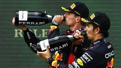 (LtoR) Winner Red Bull Racing's Dutch driver Max Verstappen and third placed Red Bull Racing's Mexican driver Sergio Perez celebrate with champagne on the podium after the Formula One Austrian Grand Prix at the Red Bull race track in Spielberg, Austria on July 2, 2023. (Photo by ERWIN SCHERIAU / APA / AFP) / Austria OUT