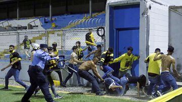 SP01. SAN PEDRO SULA (HONDURAS) 02/04/2022.- Un policía trata de intervenir en una pelea entre asistentes hoy, durante un partido entre Real España y Marathon, en el estadio Morazán de San Pedro Sula (Honduras). EFE/ José Valle
