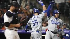 Los Angeles Dodgers&#039; Cody Bellinger, center, celebrates hitting a solo home run with Max Muncy, right, as Colorado Rockies catcher Chris Iannetta stands in the foreground in the eighth inning of a baseball game Sunday, April 7, 2019, in Denver. (AP Photo/David Zalubowski)