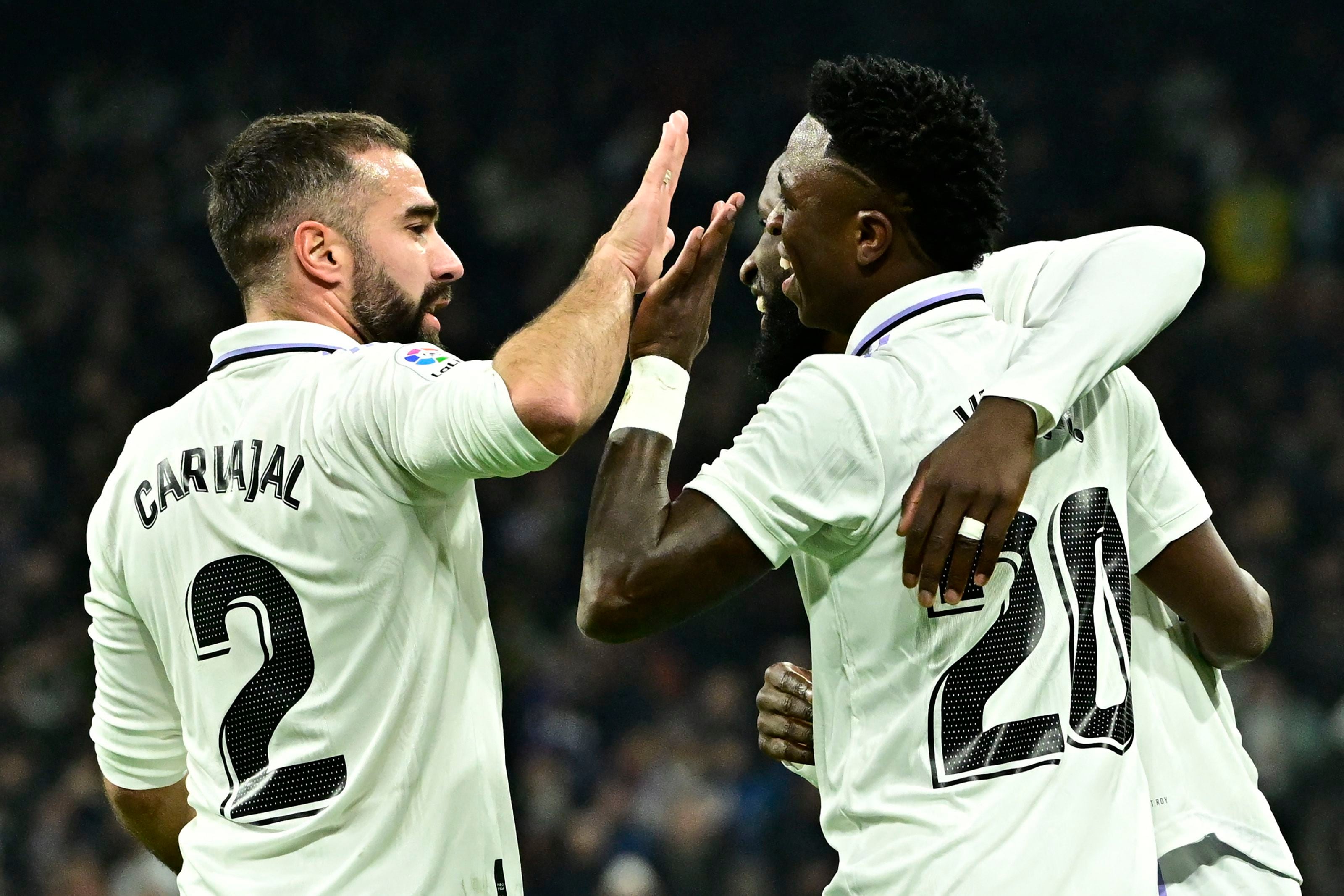 Real Madrid's Brazilian forward Vinicius Junior (R) celebrates scoring his team's second goal with Real Madrid's Spanish defender Dani Carvajal (L) and Real Madrid's German defender Antonio Rudiger during the Spanish league football match between Real Madrid CF and Valencia CF at the Santiago Bernabeu stadium in Madrid on February 2, 2023. (Photo by JAVIER SORIANO / AFP)