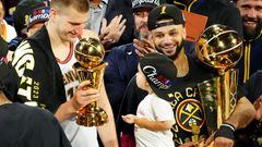 Jun 12, 2023; Denver, Colorado, USA; Denver Nuggets center Nikola Jokic (15) celebrates with the Bill Russell NBA Finals MVP Award as guard Jamal Murray (27) holds the Larry O'Brien Trophy after the Nuggets won the 2023 NBA Championship against the Miami Heat at Ball Arena. Mandatory Credit: Ron Chenoy-USA TODAY Sports